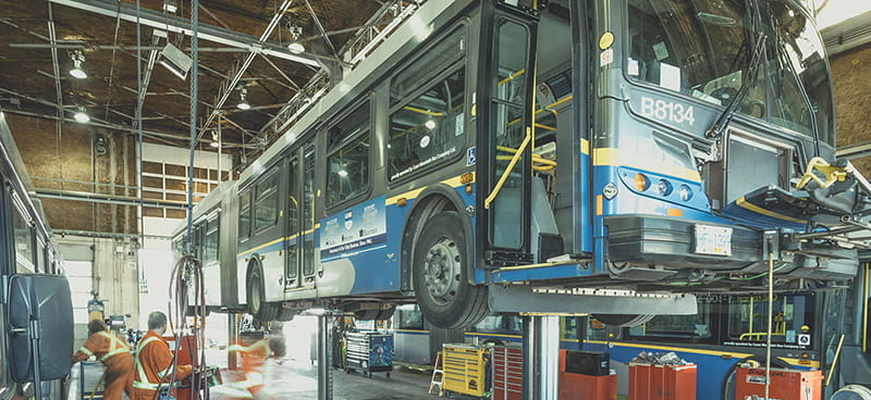 Technicians repairing a bus inside a CMBC workshop