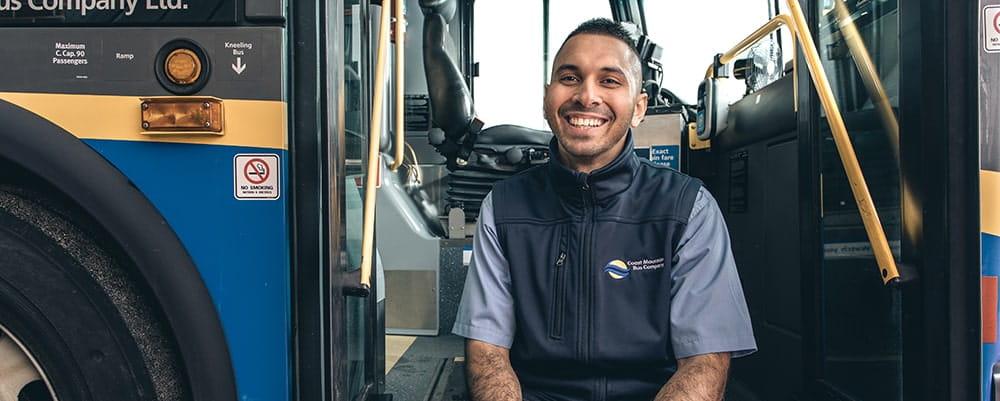 A bus operator sitting on the stairs of the bus