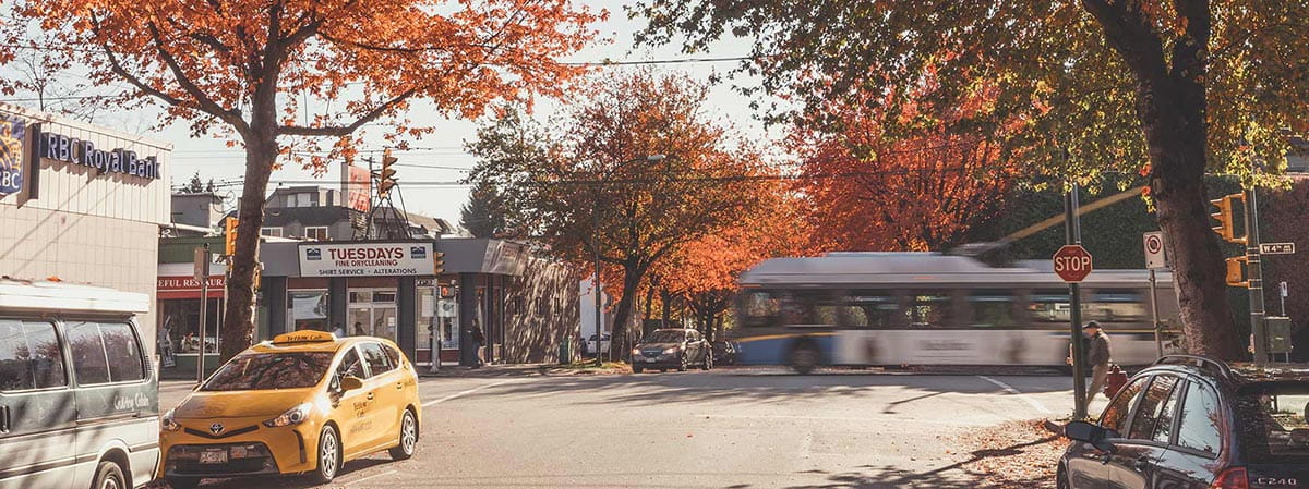 A bus driving past an empty street in Autumn