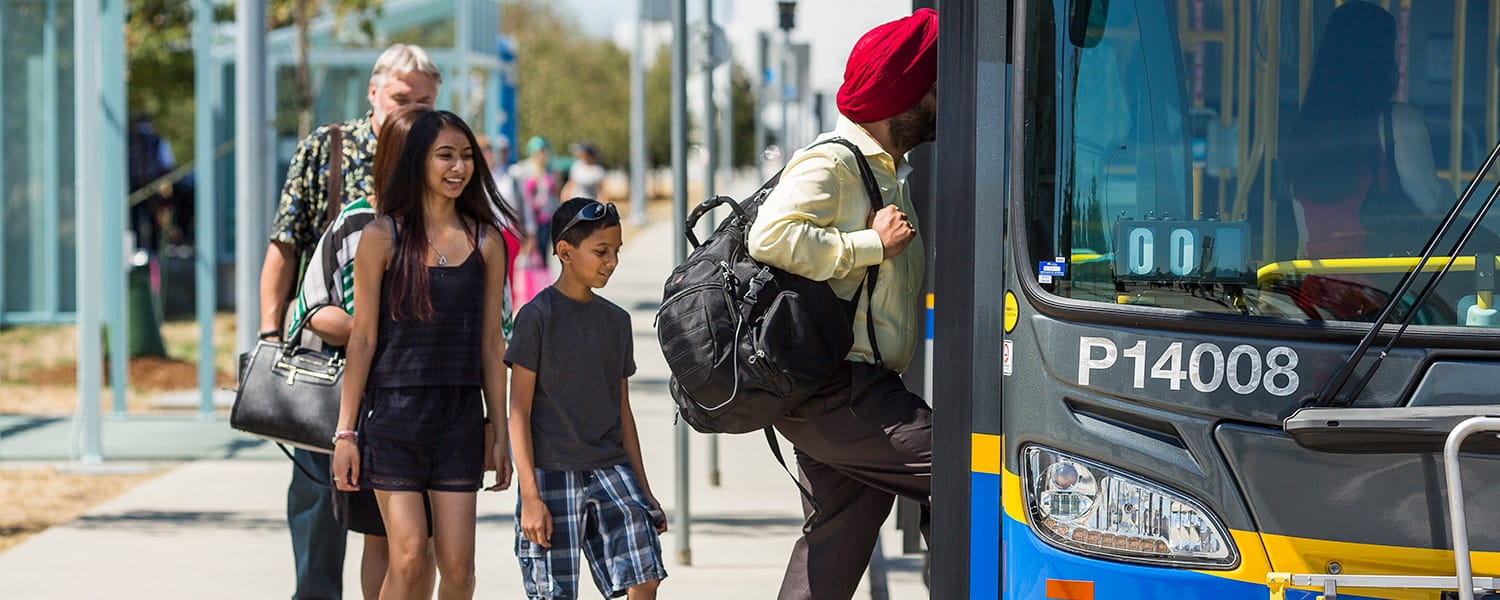 A small group of people boarding a bus and paying fare